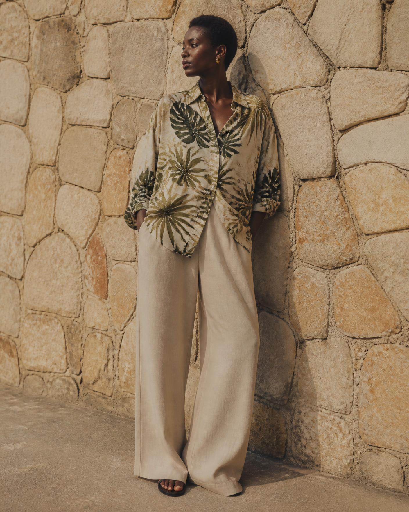 Lookbook — Nigerian female model wearing the Tropical Leaf Printed Resort Shirt against a stone wall